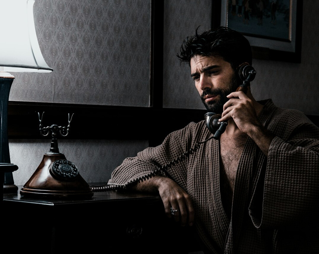 Man in a suit talking on the phone at his desk